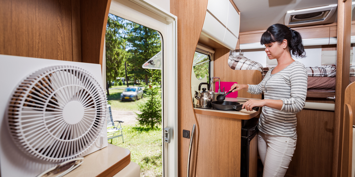 Woman cooking in camper, motorhome RV interior. Family vacation travel, holiday trip in motorhome, Caravan car Vacation.