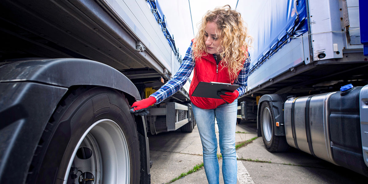 Truck driver checking vehicle tires and inspecting truck before ride. Transportation services.